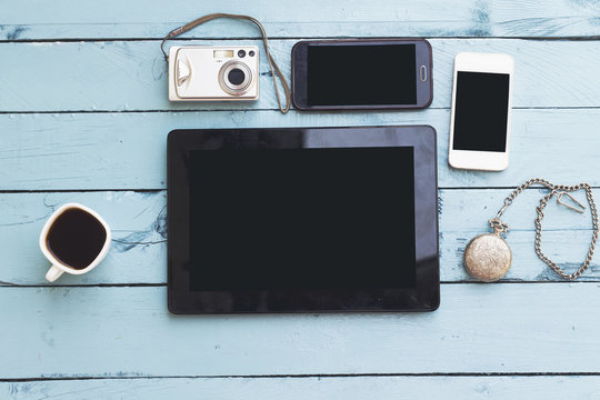 coffee cup, camera, phones, ipad and old watch on blue table