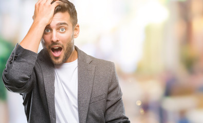 Obraz premium Young handsome business man over isolated background surprised with hand on head for mistake, remember error. Forgot, bad memory concept.