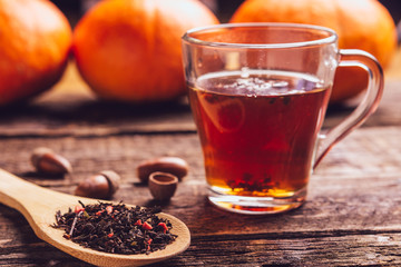 glass cup with tea and wooden spoonful of berry herbal tea