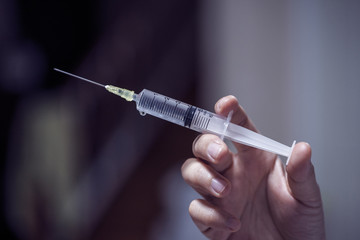 A syringe in the hands of a nurse.