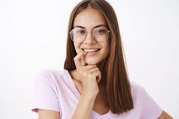 Girl being intrigued listening guy invites on date thinking to accept offer. Charming flirty and confident feminine young woman in glasses holding finger on lower lip and smiling with desire