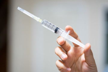 A syringe in the hands of a nurse.