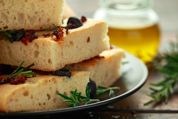 Homemade Italian focaccia with sun dried tomatoes, black olives and rosemary