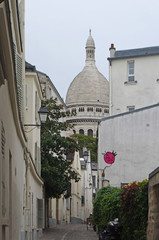 Houses and rue de Montmartre in Paris with the basilica in the background