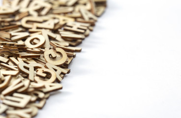 Wooden letters on a pile on left side of a white paper. Copy space.  