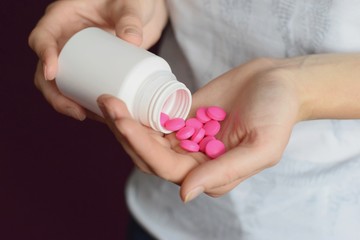 Obraz na płótnie Canvas Woman having pink pills in the hand