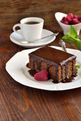 Slice of chocolate cake with glaze and raspberries,  vertical