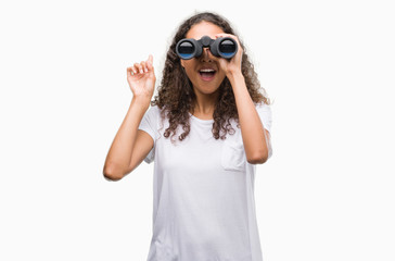 Young hispanic woman looking through binoculars surprised with an idea or question pointing finger with happy face, number one