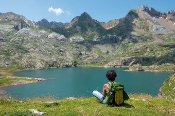 woman hiker resting and  looking at lake in the Pyrenees mountains