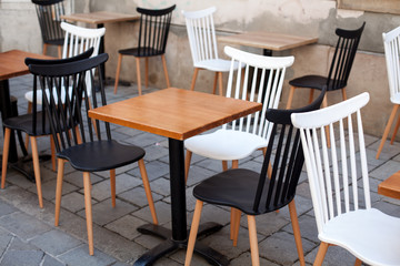 Fototapeta na wymiar View of empty outdoor terrace cafe outdoor with retro wooden chairs and table in sunny summer day