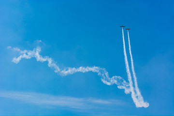 Two Airplanes Synchronously Ascending in a Long Trail on the Blue Sky