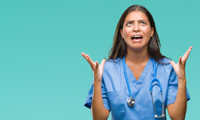 Young arab doctor surgeon woman over isolated background crazy and mad shouting and yelling with...