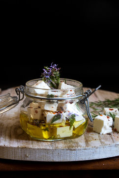 in Olivenöl eingelegter Schafskäse mit Rosmarin und roten Paprika