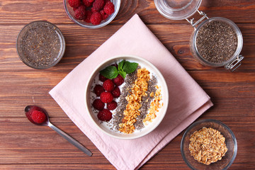 chia pudding in a bowl on the background of a tree view from above. Useful breakfast, useful supplements, super food.