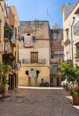 Fototapeta na wymiar Cozy italian backyard with balcony, drying clothes and motorcycle. Traditional mediterranean architecture. Italian town landmark. Travel and vacation background. 