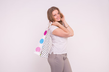 Happy european plus-size woman holding shopping bags on white background