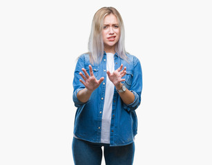 Young blonde woman over isolated background disgusted expression, displeased and fearful doing disgust face because aversion reaction. With hands raised. Annoying concept.