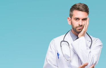 Young handsome doctor man over isolated background thinking looking tired and bored with depression problems with crossed arms.