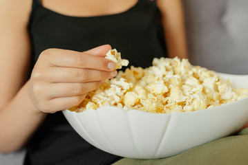 Close-up view of a woman eating a popcorn, at home