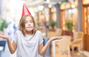 Young beautiful girl wearing birthday cap over isolated background clueless and confused expression...