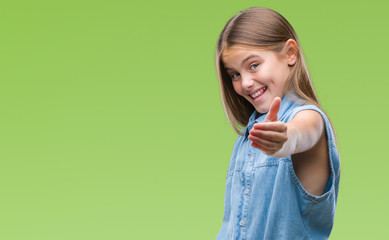 Young beautiful girl over isolated background smiling friendly offering handshake as greeting and welcoming. Successful business.