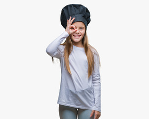 Young beautiful girl wearing chef hat uniform over isolated background doing ok gesture with hand smiling, eye looking through fingers with happy face.
