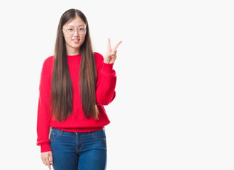 Obraz na płótnie Canvas Young Chinese woman over isolated background wearing glasses showing and pointing up with fingers number two while smiling confident and happy.