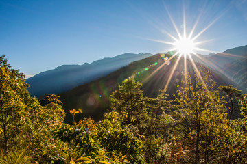 Sun light like star, blue sky with mountains and forest