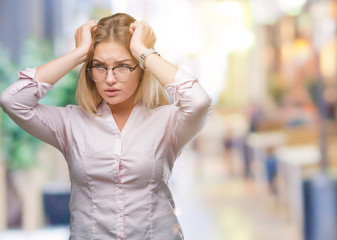 Young caucasian business woman wearing glasses over isolated background suffering from headache desperate and stressed because pain and migraine. Hands on head.