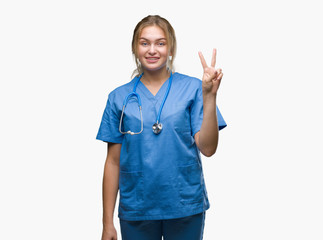 Young caucasian doctor woman wearing surgeon uniform over isolated background showing and pointing up with fingers number two while smiling confident and happy.