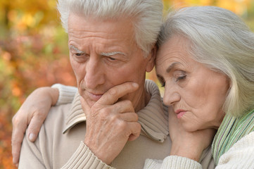 Elderly couple at table in autumn forest