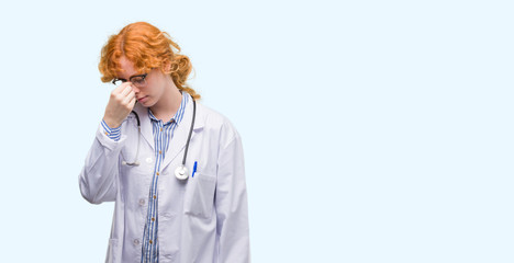 Young redhead woman wearing doctor uniform tired rubbing nose and eyes feeling fatigue and headache. Stress and frustration concept.