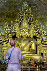 Tourist or Europion woman pay golden Buddha in Temple at Mandalay Hill, Myanmar. landmark and popular for tourist attractions