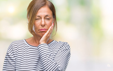 Middle age senior hispanic woman over isolated background thinking looking tired and bored with depression problems with crossed arms.