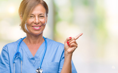 Middle age senior nurse doctor woman over isolated background with a big smile on face, pointing with hand and finger to the side looking at the camera.