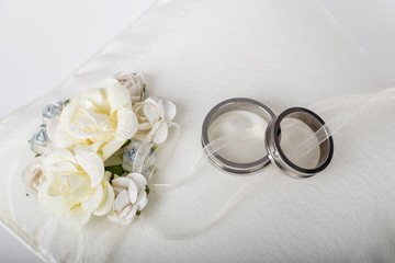  wedding rings - silver wedding rings on a white silk pillow