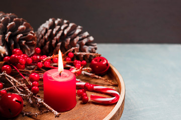 Seasonal and holidays concept. Decorative composition with candle, fir cones, winter background. Selective focus.