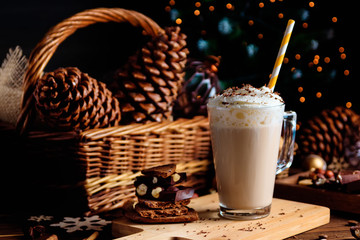 Hot chocolate drink with whipped cream. Cozy Christmas composition on a dark wooden background. Sweet treats for cold winter days.