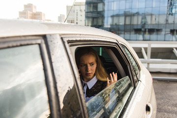 Sad girl at car window during rainy day