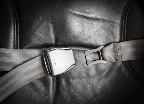 Close Up Shot In Passenger Airplane Of Seat Belt Silver Buckle Opened In Cabin. Safety Concept.