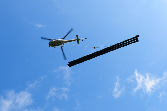 Air Engadin Helikopter is flying with water-pipelines from Silvaplana to Furtschella