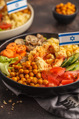 Buddha bowls with vegetables, mushrooms, bulgur, hummus and baked chickpeas. Israeli food concept.