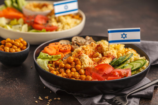 Buddha bowls with vegetables, mushrooms, bulgur, hummus and baked chickpeas. Israeli food concept.