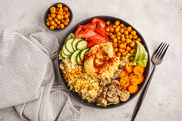 Buddha bowl with vegetables, mushrooms, bulgur, hummus and baked chickpeas. White background, top view.