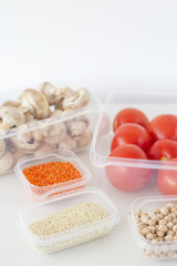 Fototapeta na wymiar Storage of vegetarian food in plastic containers. A healthy diet with vegetables, fruits, cereals and legumes. Order in the kitchen concept