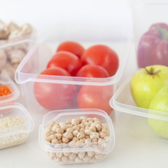 Storage of vegetarian food in plastic containers. A healthy diet with vegetables, fruits, cereals and legumes. Order in the kitchen concept