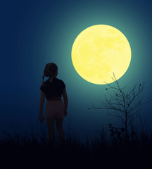 A young girl looks at a huge moon at full moon.