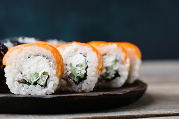 Japanese restaurant menu photo, seafood, national cuisine. Delicious sushi. Appetizing rolls served on black tray, selective focus. Copy space for text design