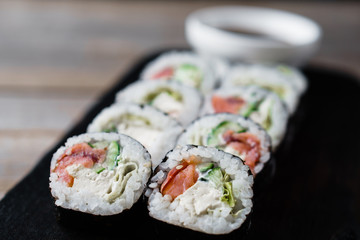 Restaurant menu, Japanese traditional food. Appetizing sushi rolls served on wooden tray