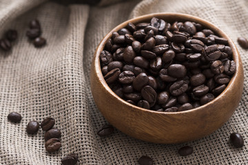 Dry roasted coffee beans in wooden bowl